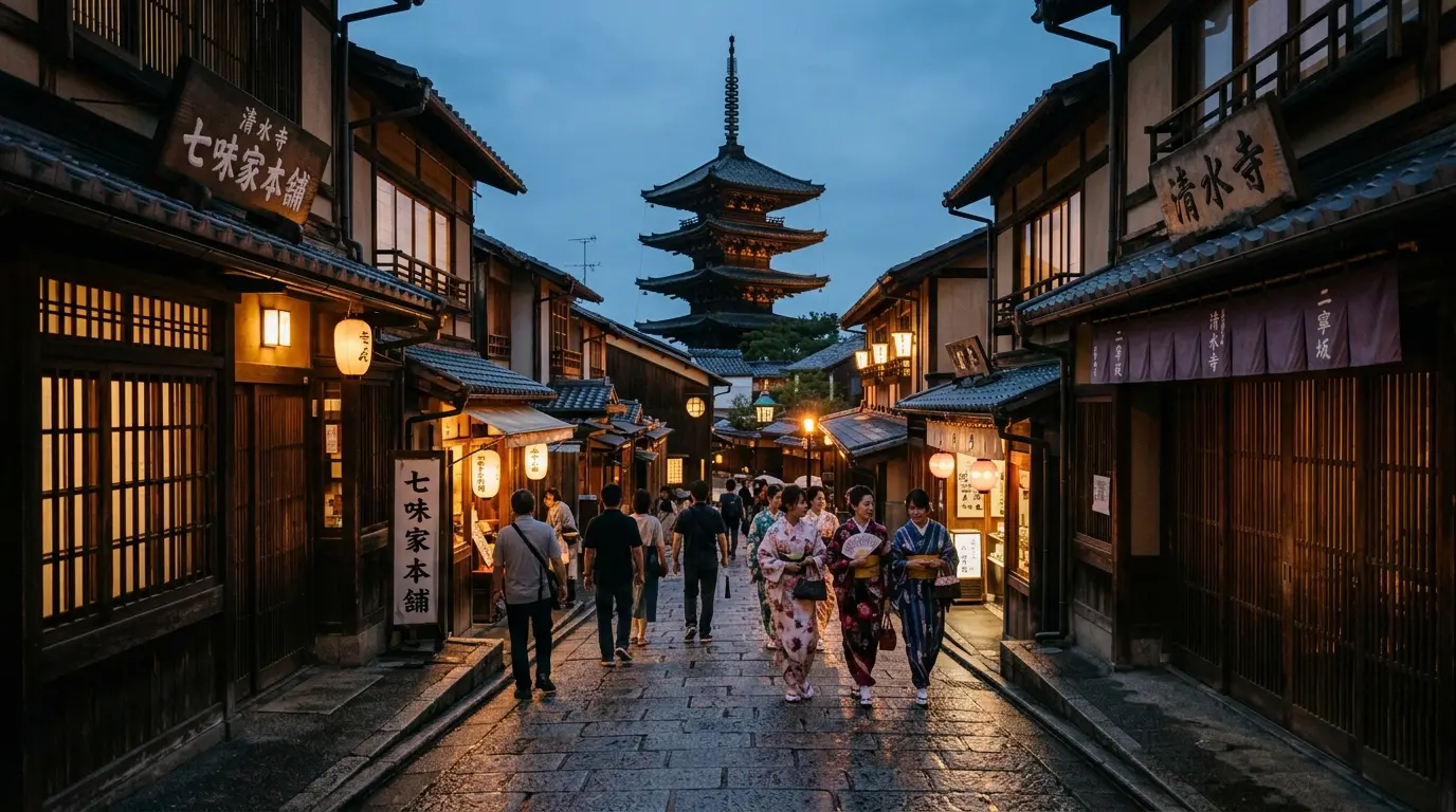Lantern-lit stone steps and preserved wooden merchant machiya houses along historic Ninenzaka at dusk.